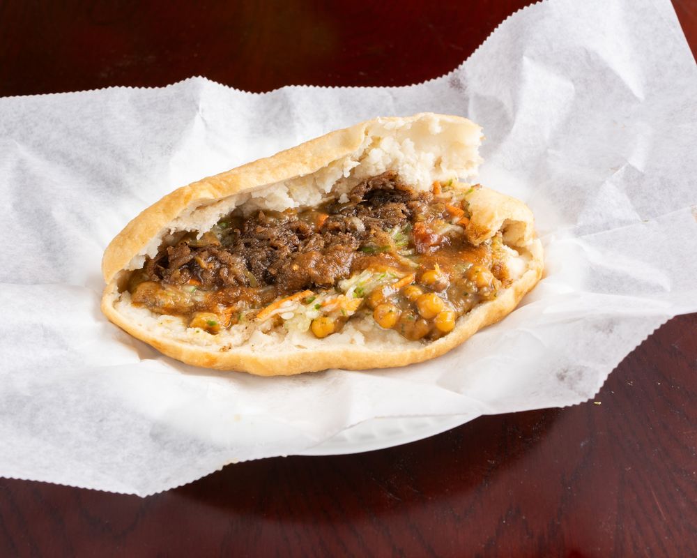 Aloo pie split open with channa and sauces